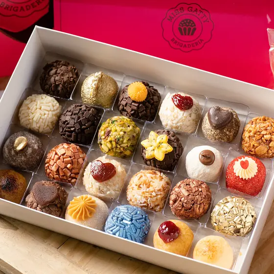 Caixa de brigadeiros gourmet Miss Gatty aberta, com a sacola da marca ao fundo